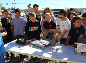 Ryder and his classmates watch a sixth grader do a demonstration about solar energy. 