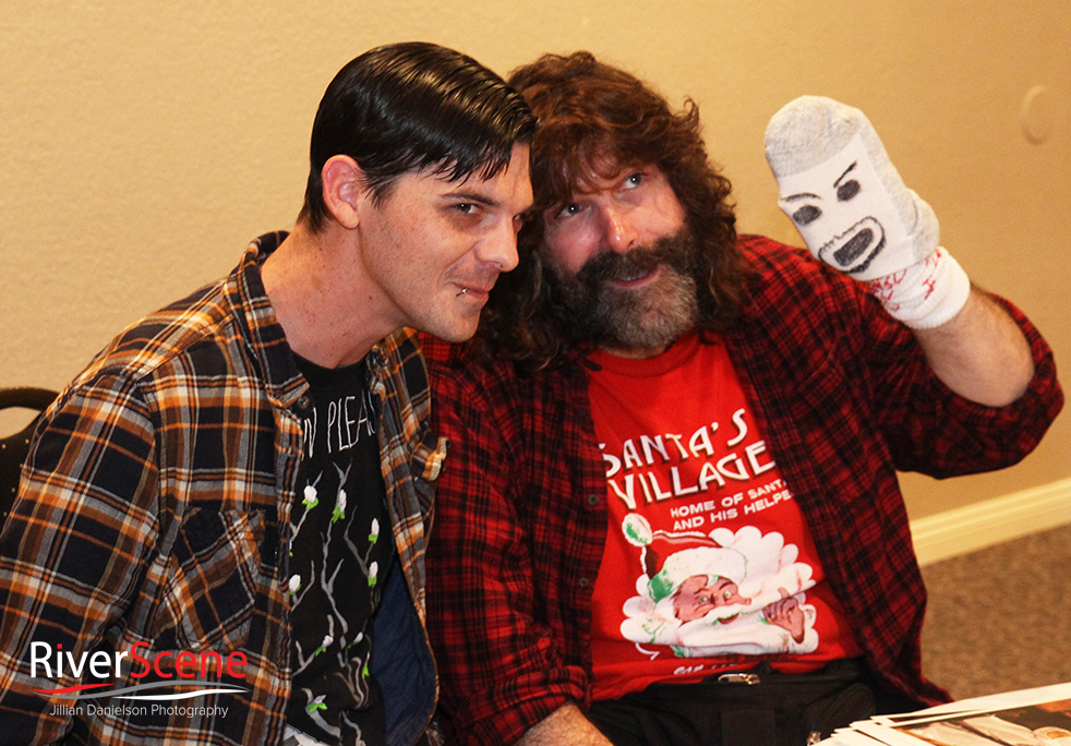 A fan takes a photo with Mick Foley during a Pennington's Pub comedy night . 
