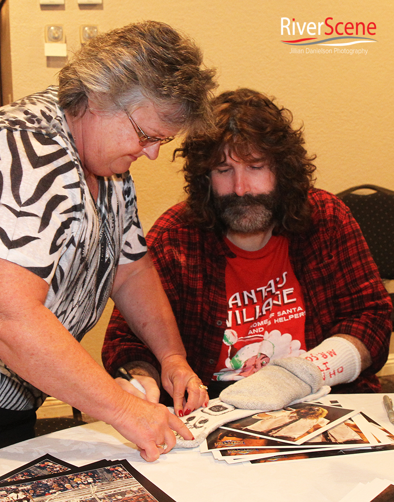Mary January gets a sock autographed Saturday evening by Mick Foley. 
