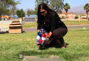 Rebecca White places flowers on a gravesite of a Veteran Tuesday morning. Jillian Danielson/RiverScene 