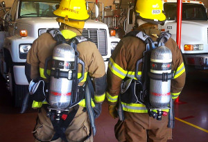 Firefighters Guy Lawrence and Jared Sison wear compressed breathing air tanks purchased by the AFG grant at the Desert Hills Fire Department Thursday afternoon. Submitted photo Stephen Bunn 