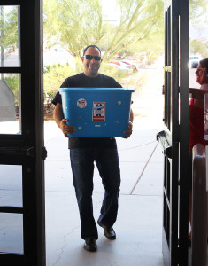 Chad Nelson of Keller Williams carries school supplies into Thunderbolt Middle School Friday morning. Jillian Danielson/RiverScene 