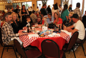 A group enjoys spaghetti at the Cooking With Cancer benefit. Jillian Danielson/RiverScene 
