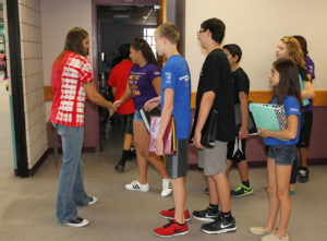 Thunderbolt students shake hands with their teacher as they enter the classroom Thursday morning. 