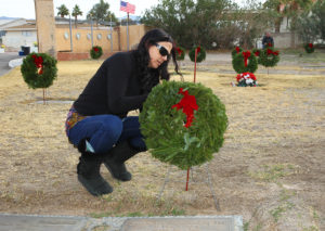 Rebecca White places a wreath on a Veteran's grave site Wednesday morning at Havasu Memorial Gardens. Jillian Danielson/RiverScene 