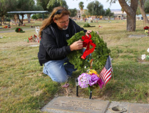 Dallas Finch places a wreath on a Veteran's grave site Wednesday morning at Havasu Memorial Gardens. Jillian Danielson/RiverScene 